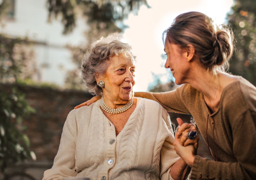 Younger woman smiling and talking to an older woman
