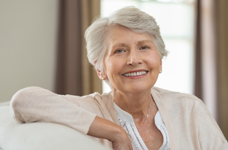 Senior woman at home smiling and looking at camera.